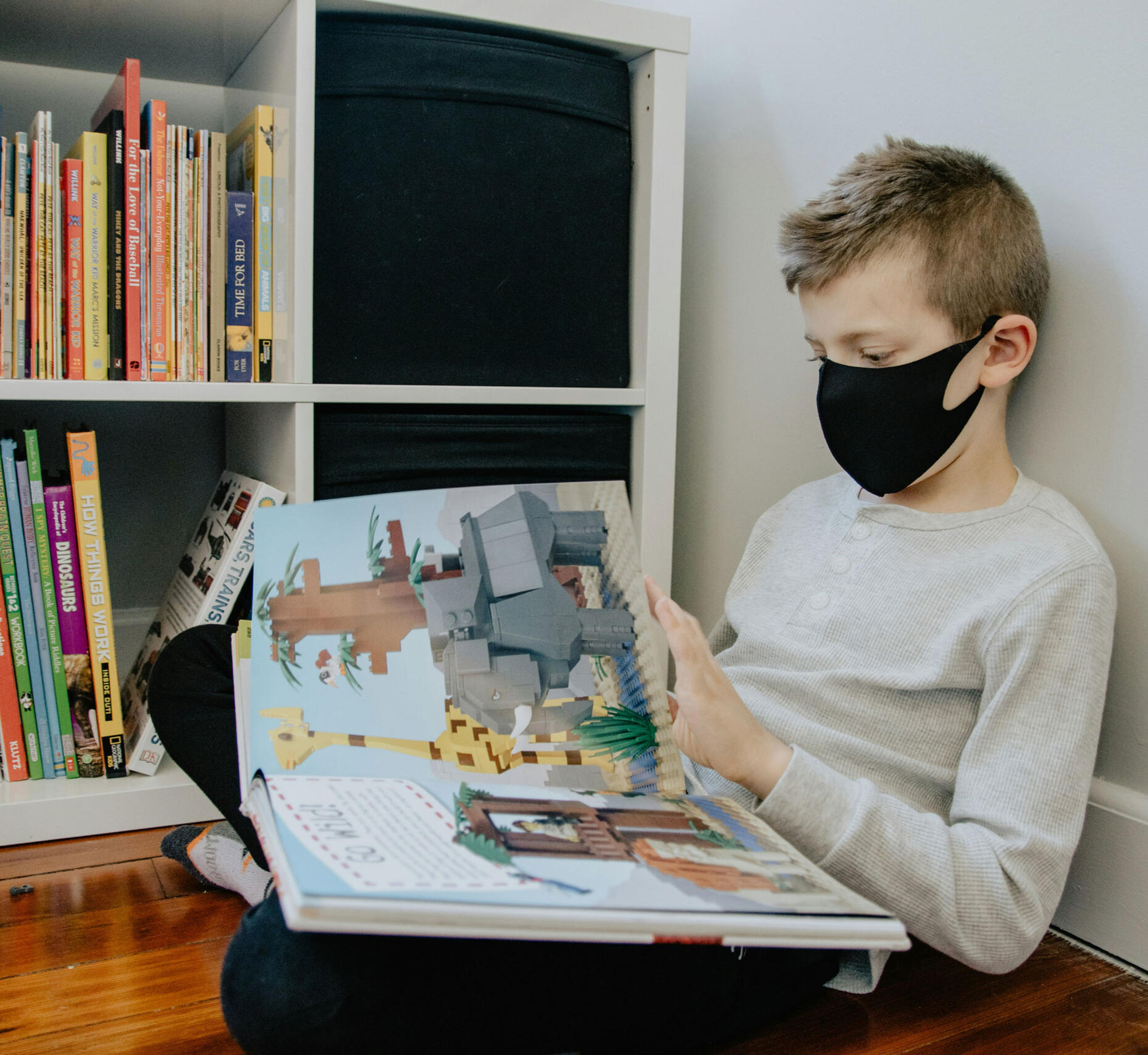 Child reading alone with a mask on. Photo by Kelly Sikkema on Unsplash.