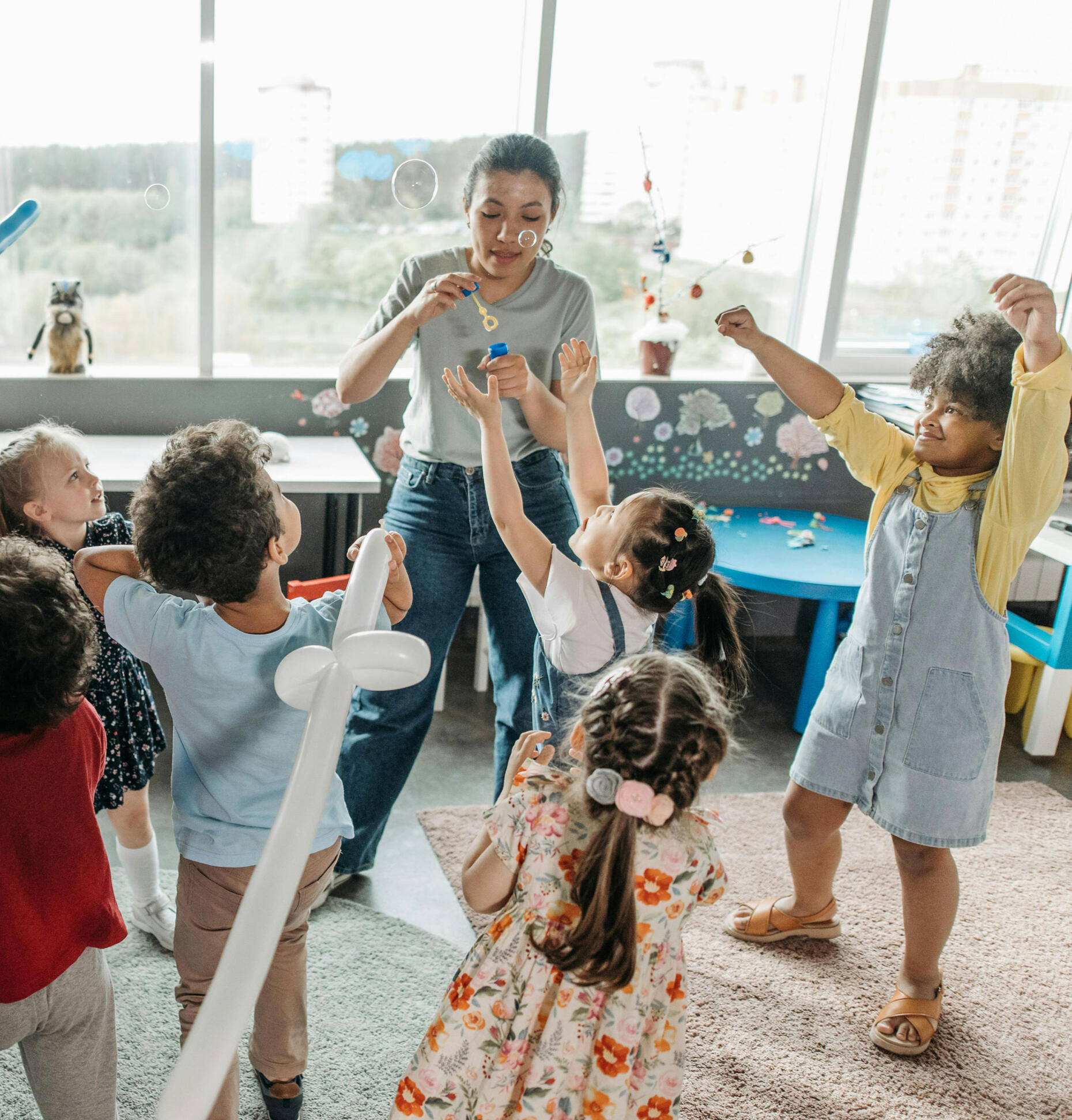 Kids playing with bubbles in the classroom together with their teacher. Photo by Pavel Danilyuk via Pexels.